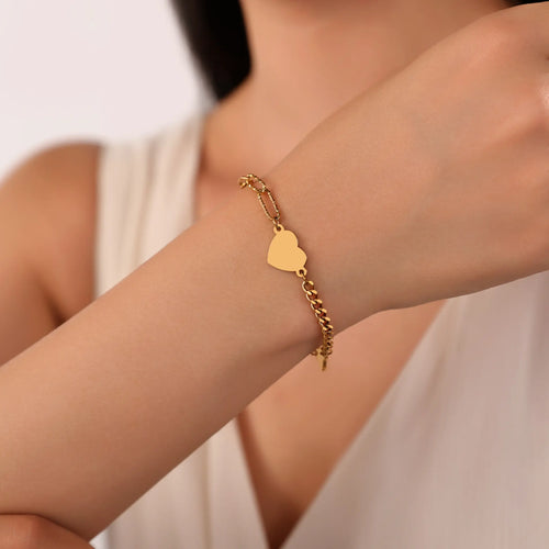 Woman wearing Vilrian gold asymmetric heart charm chain bracelet on wrist