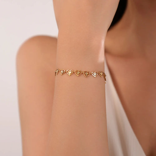 Woman wearing delicate Vilrian gold cutout heart link bracelet on wrist