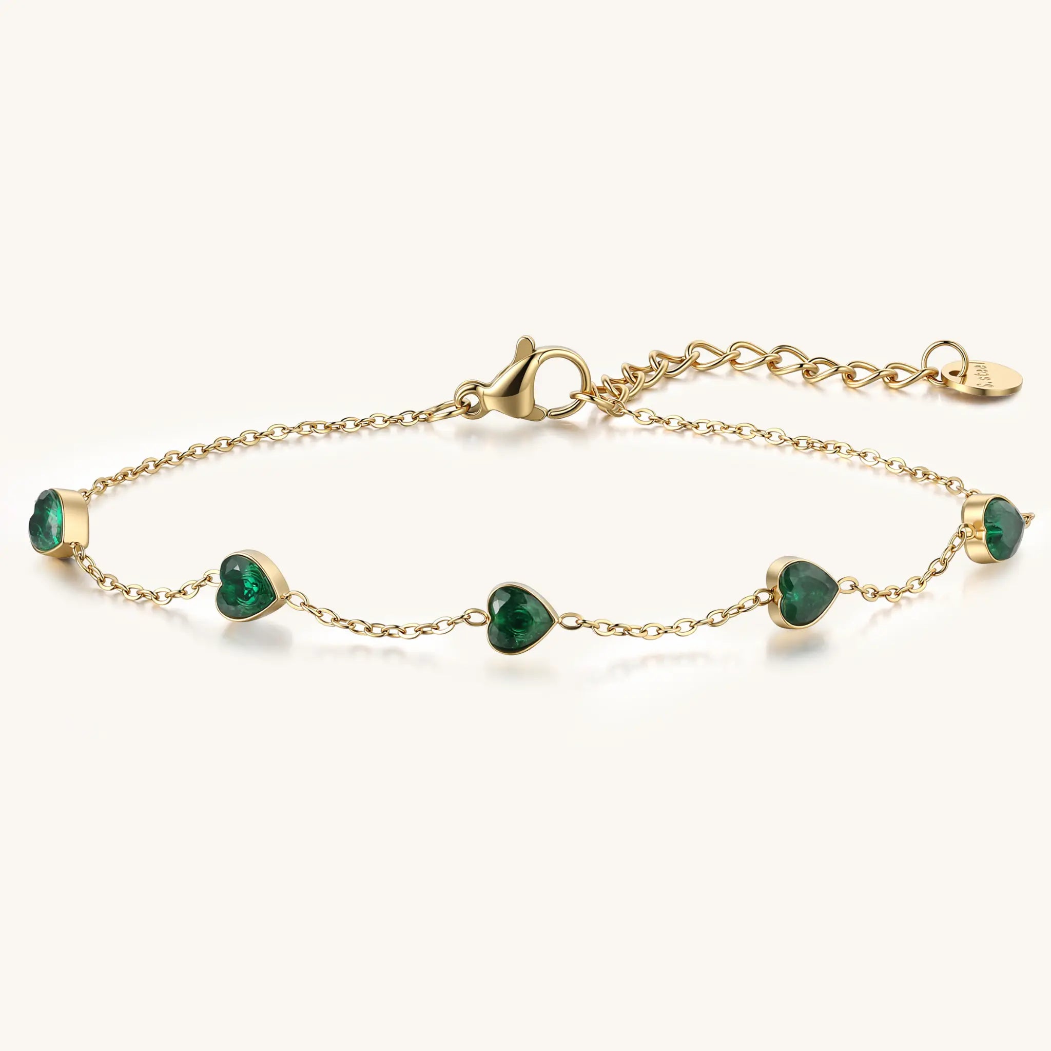 Vilrian gold plated stainless steel station bracelet with heart shaped emerald green zirconia