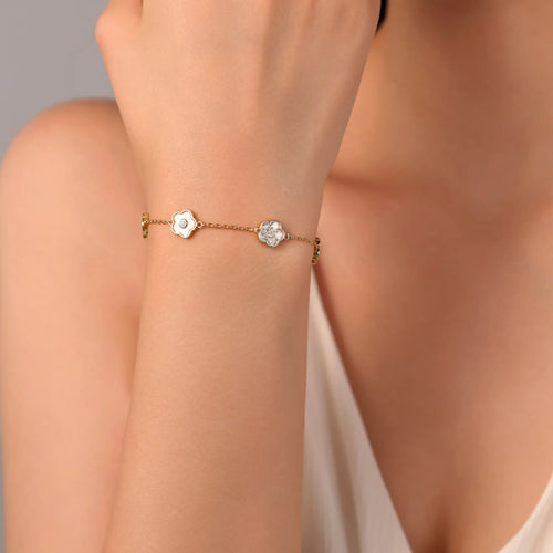 Woman wearing Vilrian gold floral charm bracelet on wrist