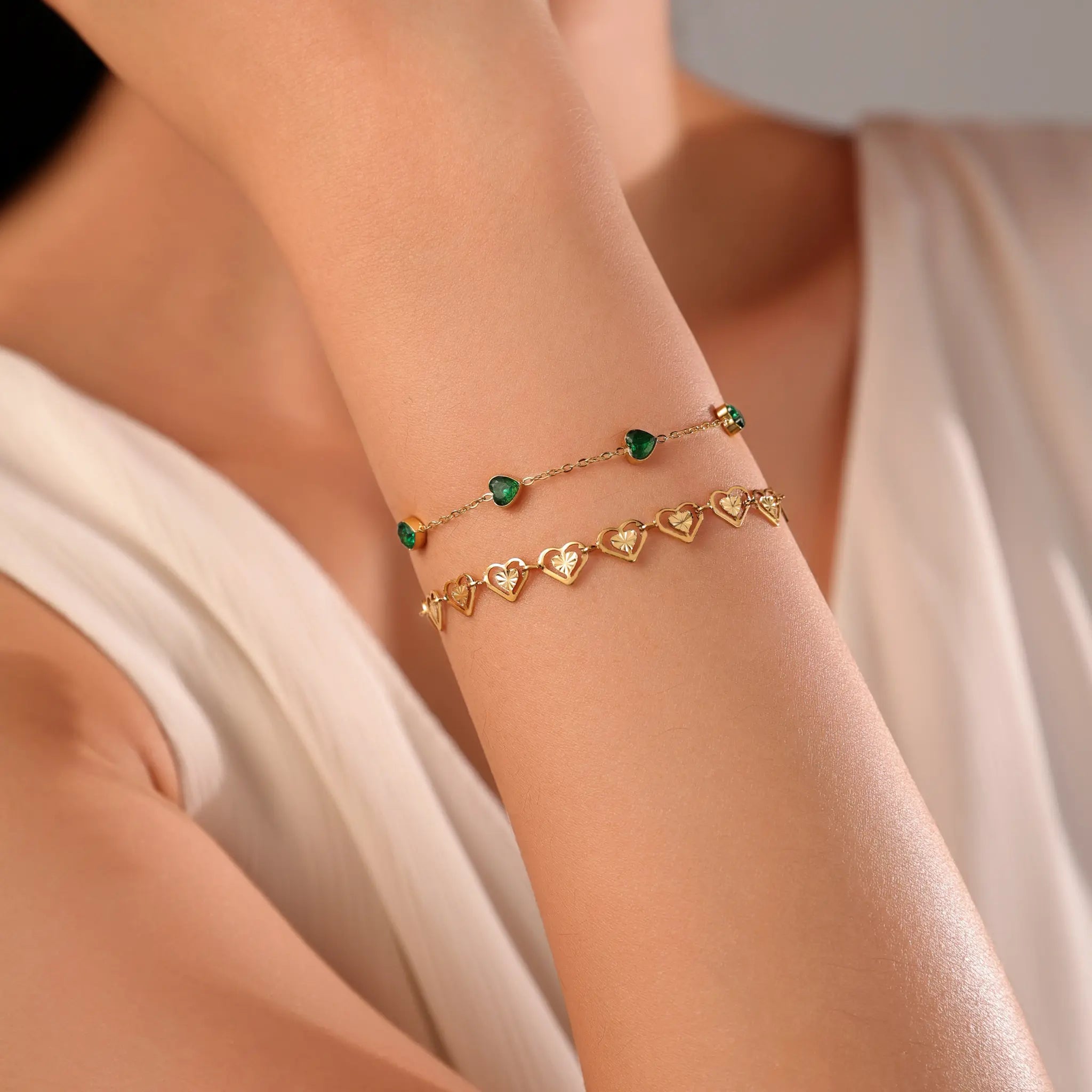Layered gold bracelet styling with Vilrian emerald green heart bracelet and carved gold heart chain