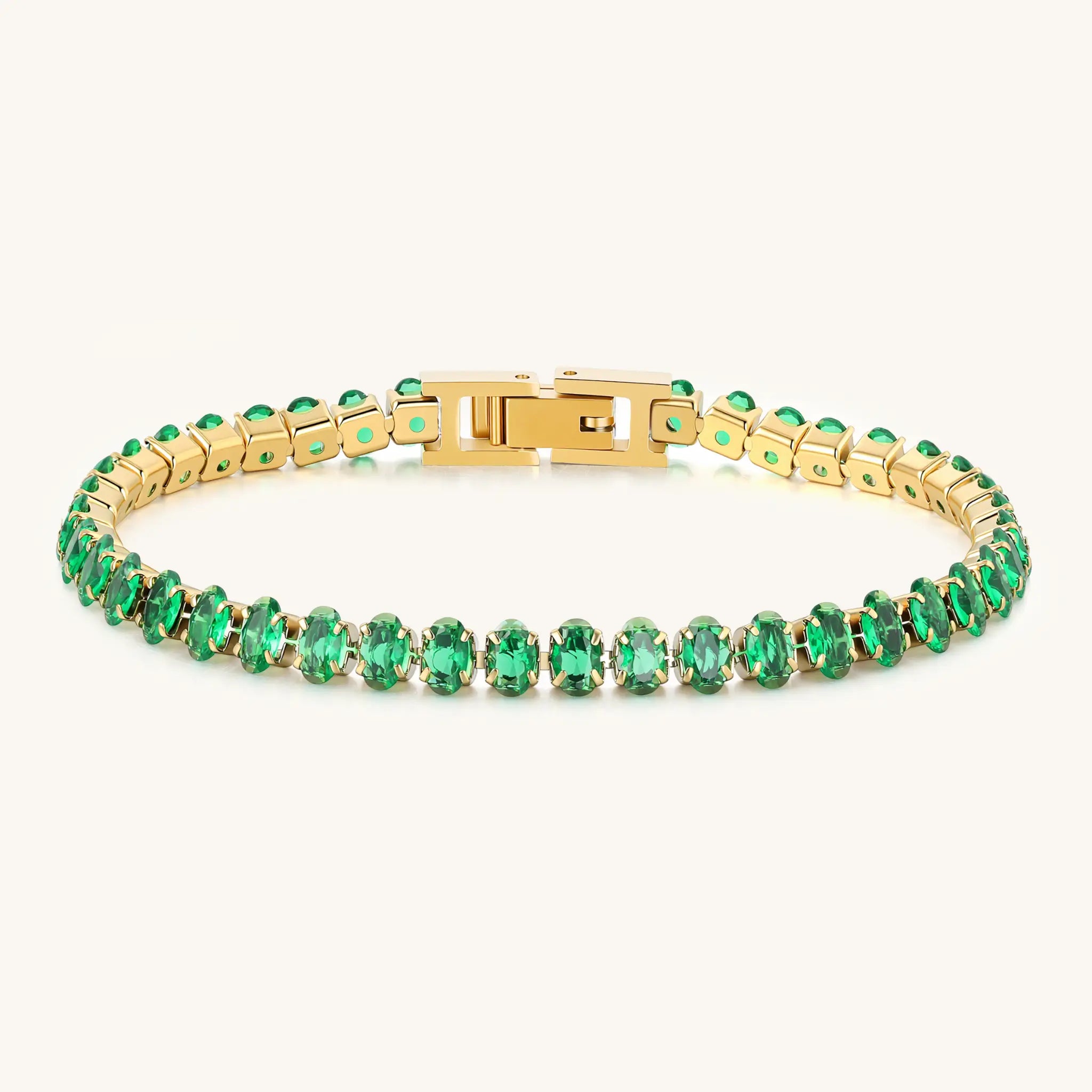 Perspective view of Vilrian gold tennis bracelet showing foldover clasp and green stones