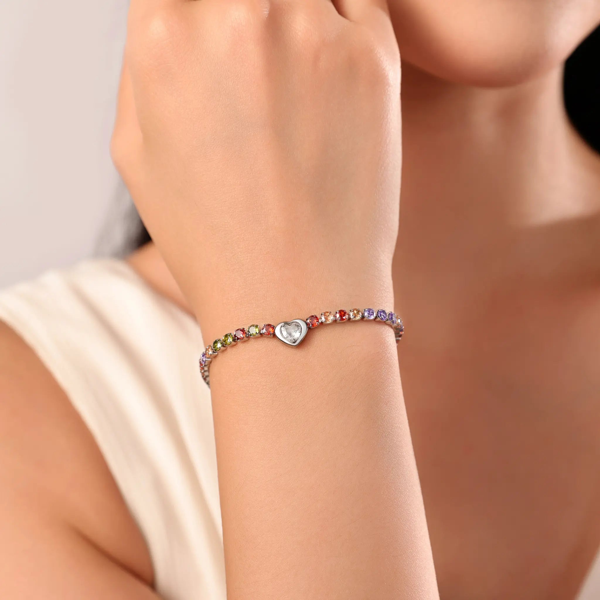 Woman wearing Vilrian colorful rainbow cubic zirconia heart tennis bracelet on wrist